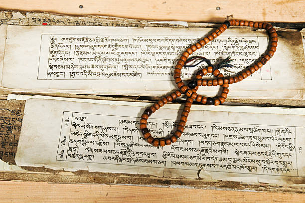 Ancient script and prayer beads ancient tibetan buddhist text with prayer beads. chanting stock pictures, royalty-free photos & images
