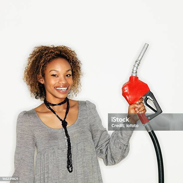 Foto de Mulher Segurando A Gás Nozzle e mais fotos de stock de Bomba de Combustível - Bomba de Combustível, Mulheres, Só Uma Mulher