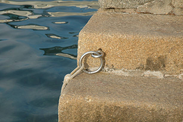 metal ring on harbour steps stock photo