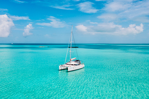 Sailing catamaran on anchorage in coral waters in Bahamas