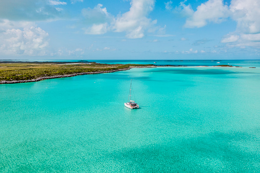 Sailing catamaran on anchorage in coral waters in Bahamas