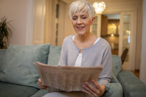 istock Senior woman reading a newspaper 1452403361