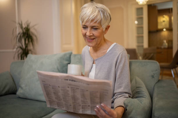 istock Senior woman reading a newspaper 1452403364