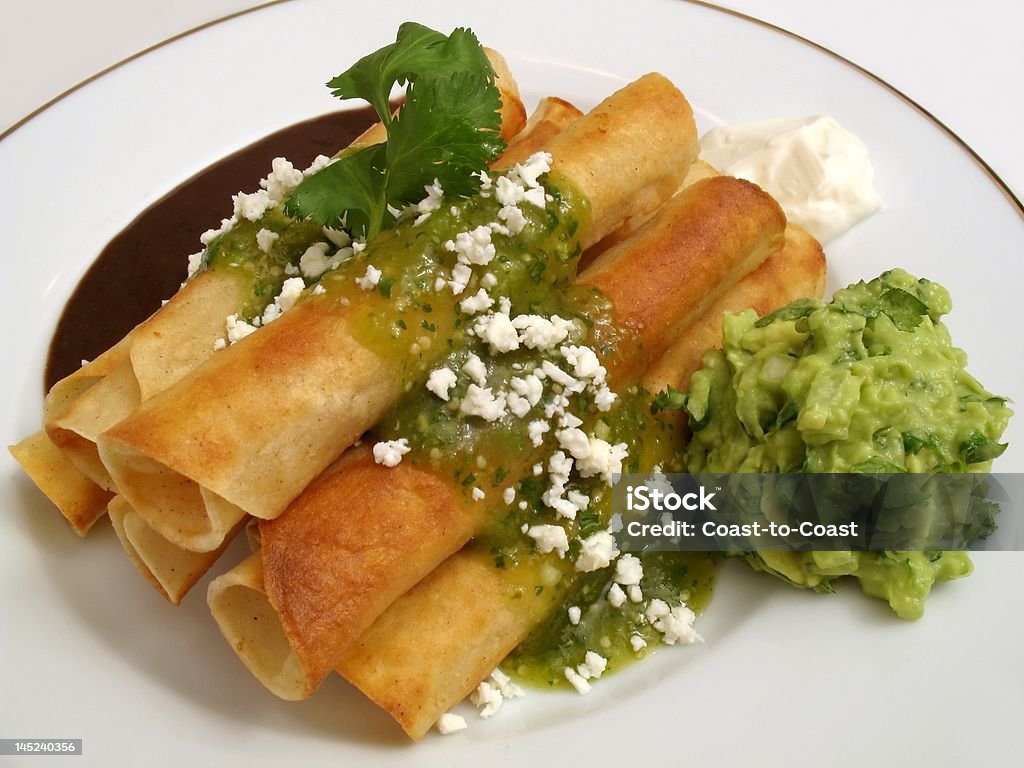 Stack of Tacos Photo of Mexican chicken tacos served with refried beans, guacamole, sour cream and then topped with tomatillo sauce and feta cheese. Chicken Taco Stock Photo