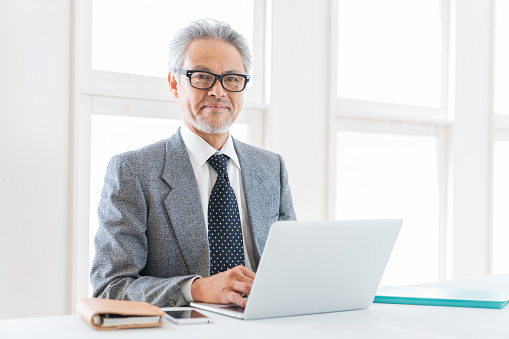 Asian elderly businessman using laptop