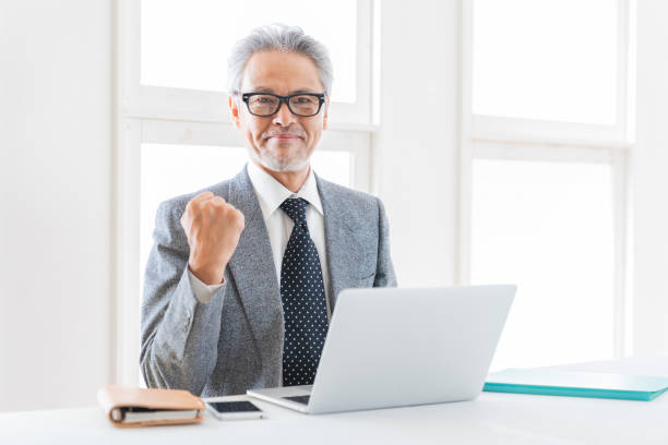 elderly businessman using laptop stock photo