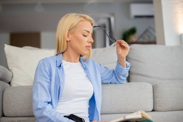 istock Happy woman reading book at home 1452409878