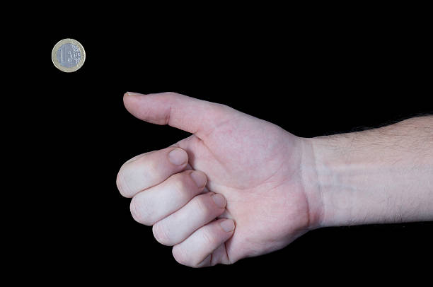 istock Hand flipping away Euro coin 145241061