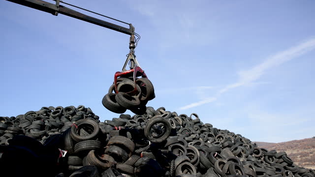 Crane hook picking up stacked tires at the landfill