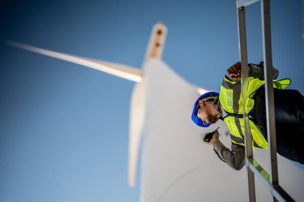 istock Asian engineers working in fieldwork outdoor. Workers check and inspect construction and machine around building project site. Wind turbine for electrical of clean energy and environment sustainable. 1452417998