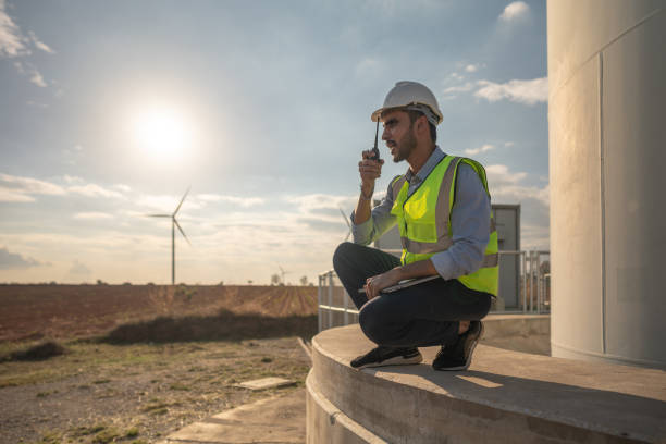 istock Asian engineer working in fieldwork outdoor. Workers check and inspect construction and machine around building project site. Wind turbine for electrical of clean energy and environment sustainable. 1452418216