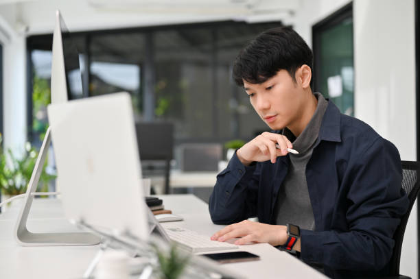 istock Asian male programmer working at his office desk. Young male officer working on his task. 1452420642