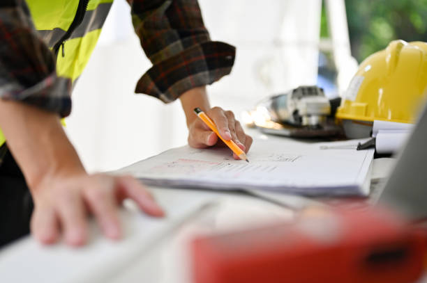 istock Professional Asian male engineer or architect looking at a building blueprint. cropped image 1452421364