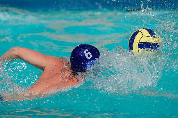 Water polo player Water polo player swimming for the ball water polo cap stock pictures, royalty-free photos & images