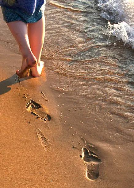 Womans legs walking on the beach