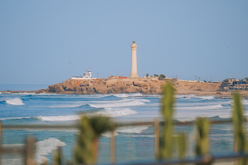 beach with strong waves beside El Hank Lighthouse in the morning at Casablanca , Morocco