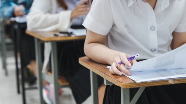 istock College students writing on final examination papers in the classroom 1452429329