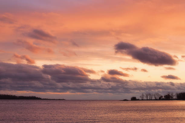 A Vibrant Orange Sunset over a Calm Lake stock photo