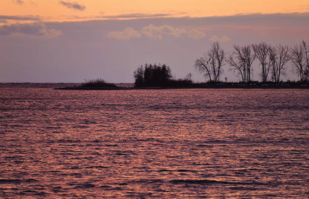 A Dramatic Purple and Orange Sunset over a Choppy Lake stock photo