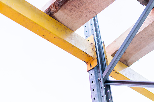 Fastening the yellow scaffold crossbars to the load-bearing beams
