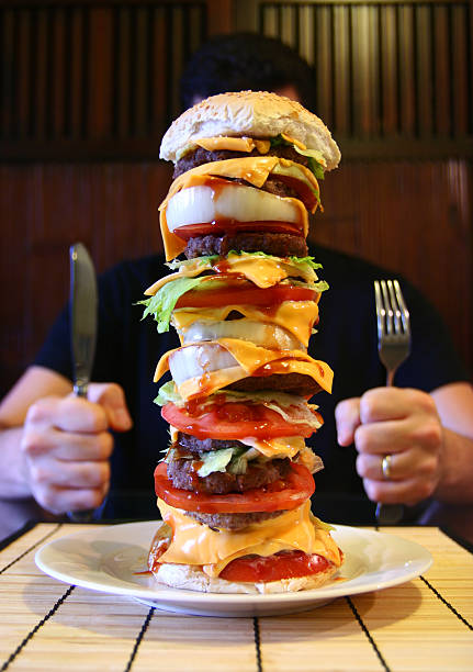 mega hamburguesa - comer demasiado fotografías e imágenes de stock