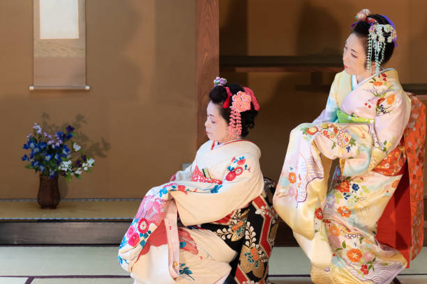 Two elderly Japanese women in kimono dancing Japanese traditional dance Two elderly Japanese woman, with hair ornament, in flower-patterned kimono, dancing Japanese traditional dance in Japanese room geisha costume stock pictures, royalty-free photos & images