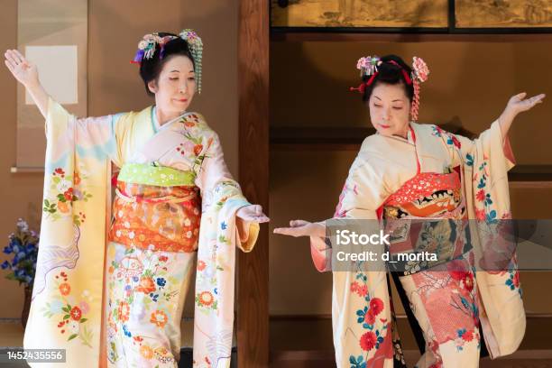 着物を着た2人の年配の日本人女性が扇子で日本の伝統舞踊を踊る