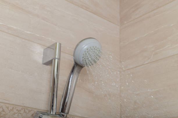 istock water flows from the showerhead. wash in the shower. chrome bathroom accessories 1452436407