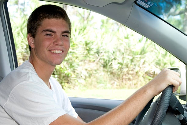 Teenage driving Happy teenage boy driving in a car, big smile on his face teenager boy driving stock pictures, royalty-free photos & images