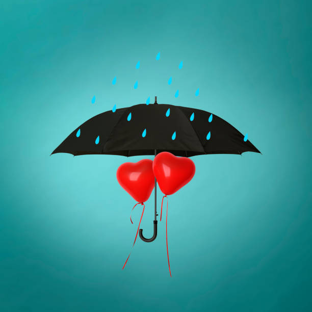 istock Umbrella to shield the red heart-shaped balloons from rain 1452439748