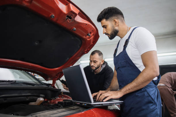 istock Young bearded men colleagues car technician mechanics repairing car problem of engine 1452439856