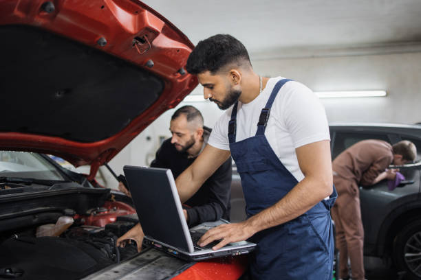 istock Young bearded men colleagues car technician mechanics repairing car problem of engine 1452439860