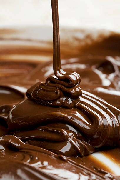 Milk chocolate being poured into bowl lots of chocolate falling from above fudge stock pictures, royalty-free photos & images