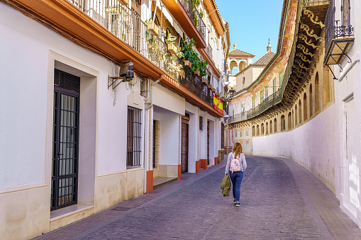 Woman strolling through the narrow streets of the medieval and picturesque town of Ecija, Seville