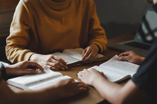 christian couple or group reading study the bible together and pray at a home or sunday school at church. concept studying the word of god. - küçük bir grup stok fotoğraflar ve resimler