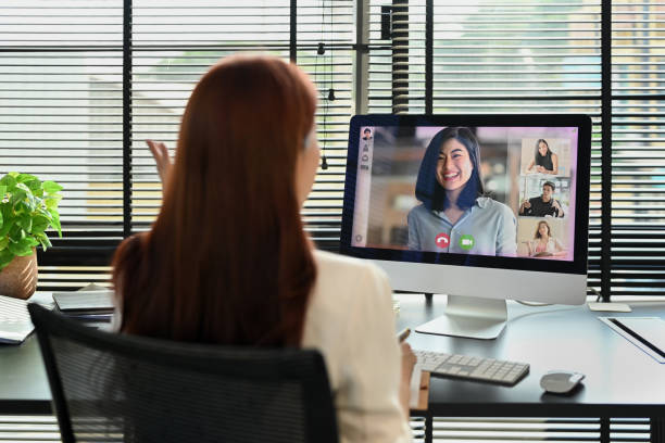 istock Back view of businesswoman discussing issues remotely online via videoconference app on computer. 1452442079