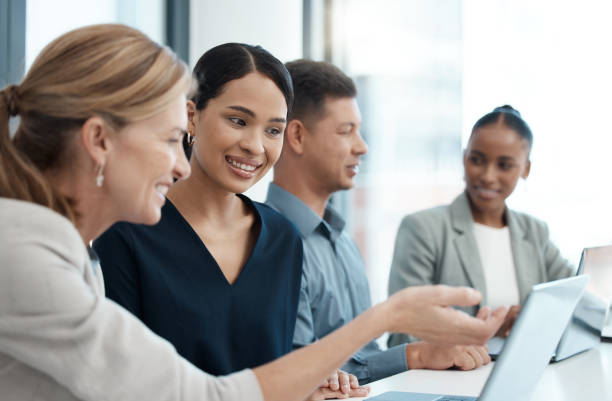 istock Teamwork, diversity and coaching with laptop in startup office checking productivity report. New deal, online project or strategy planning, men and women in partnership at corporate business meeting. 1452442176