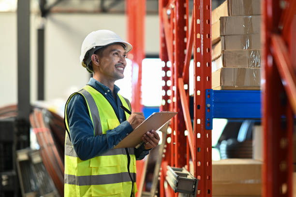 istock Warehouse managers standing between retail warehouse full of shelves and checking supply export shipment. 1452442195