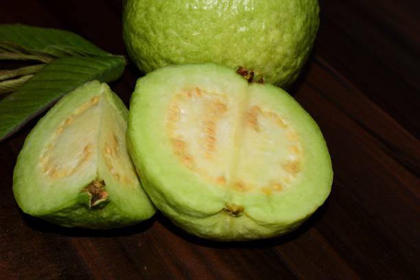 istock Fresh guava fruit with green leaf on the wooden table 1452442239