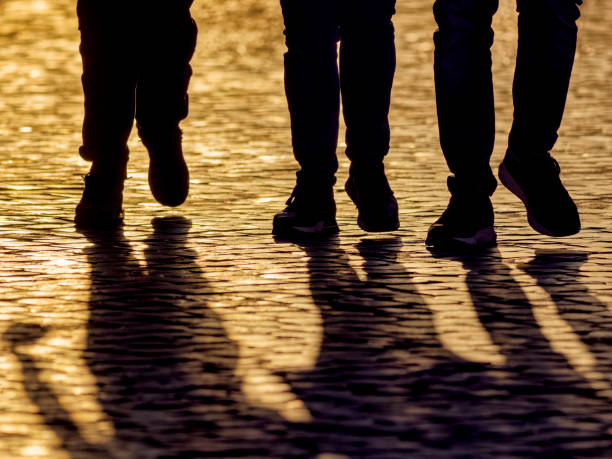 Friends walking down a cobbled street at sunrise in Rome Italy