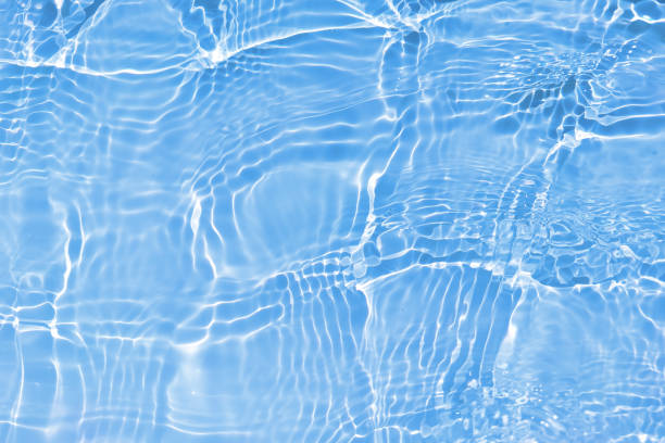 istock Defocus blurred transparent blue colored clear calm water surface texture with splashes and bubbles. Trendy abstract nature background. Water waves in sunlight with caustics. Blue water shinning 1452444705