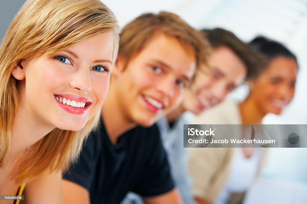 Close-up de uma jovem mulher estudante sorridente com os seus colegas de escola - Royalty-free Pessoa a Estudar Foto de stock