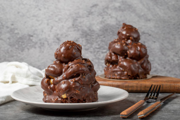 istock Chocolate cake on a dark background. Dessert with chocolate sprinkled on profiteroles grains. Bakery products 1452447433