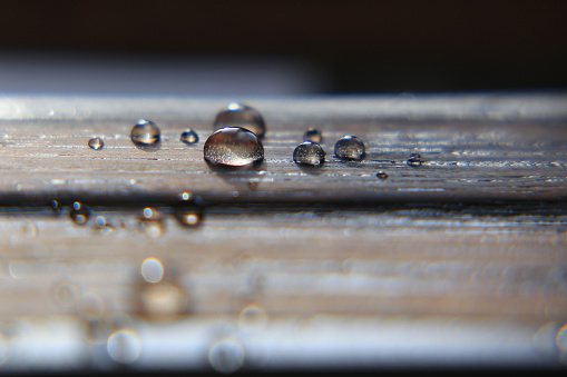 Close up of water drops on impregnated wooden surface.