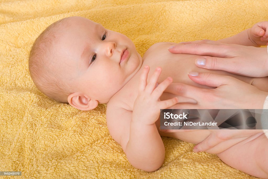 Massaging baby Hands of mother massaging a baby. Focus on face Baby - Human Age Stock Photo