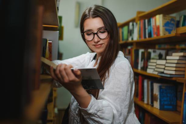 istock Education, high school, university, learning and people concept. Smiling student girl reading book 1452454022