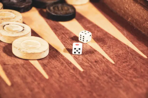 Two dice rolled on a backgammon game board. Backgammon game black versus white with dice. Backgammon set with rolling dice