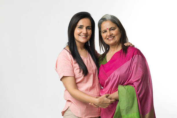 retrato de una alegre anciana india posando con una hija adulta sobre fondo blanco - indian culture women india indian ethnicity fotografías e imágenes de stock