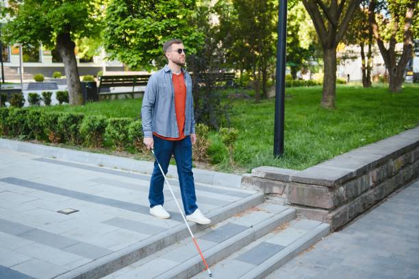 istock Young handsome blinded man walking with stick in town 1452457690
