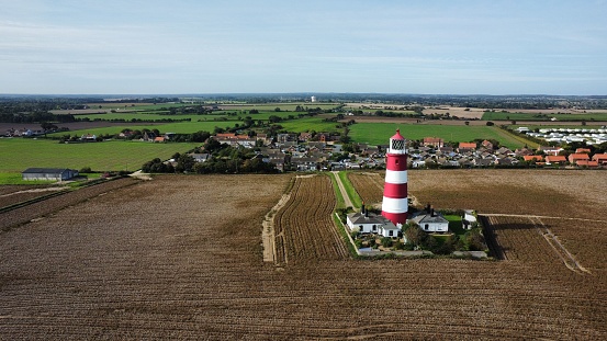 A beautiful view of a lighthouse with field and village around